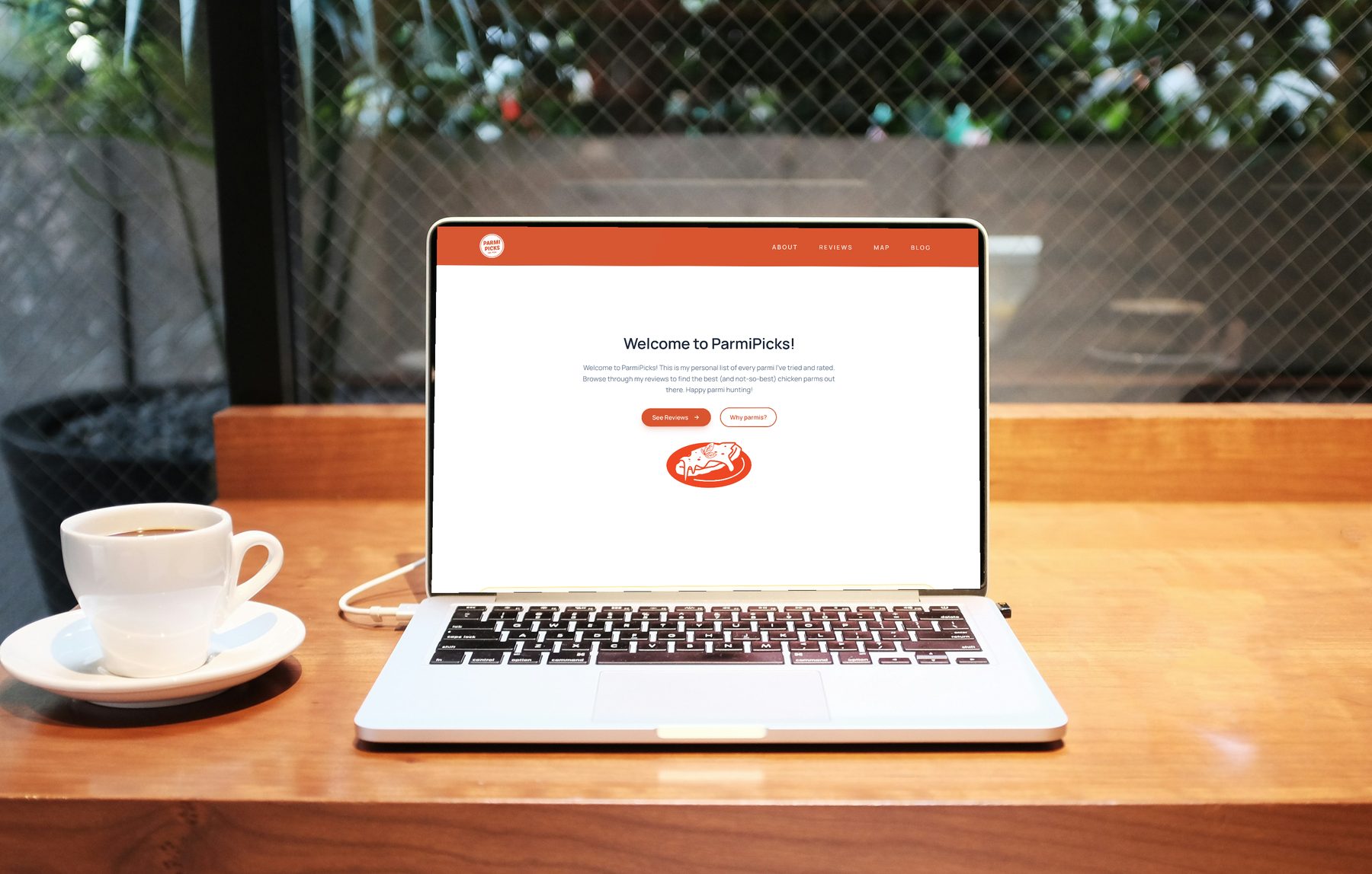 The Parmi Picks site shown on a laptop on a café table